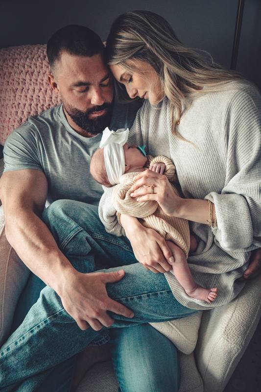 Father holding his newborn beside the mother
