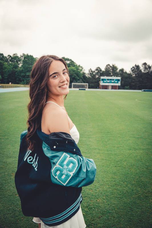 Young woman in a jacket on a soccer field