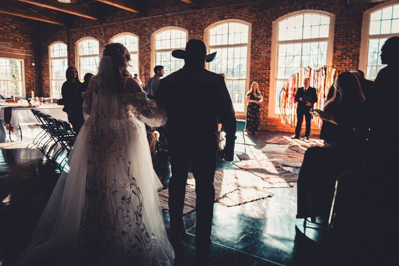 Wedding guests in a hall with tall arched windows
