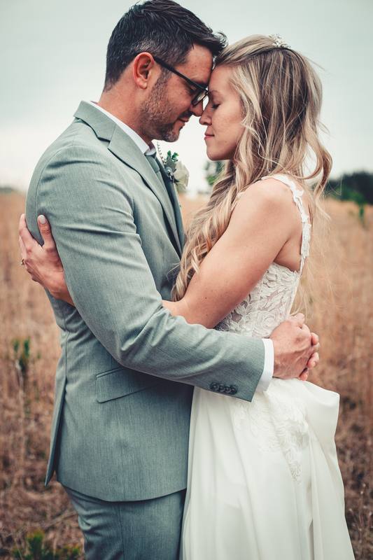 Couple in a golden field on their wedding day