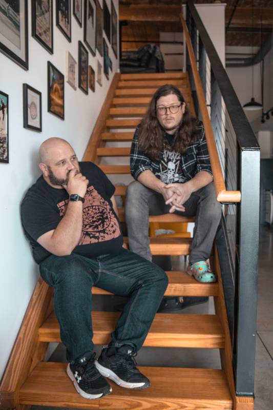Two men talking on a wooden staircase