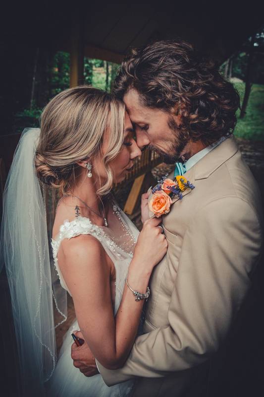 Bride and groom forehead to forehead by a window